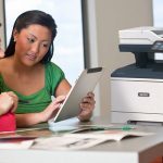 Xerox® VersaLink® B415 Multifunktionsdrucker am Arbeitsplatz Zwei Frauen nutzen ein Tablet vor einem Xerox® VersaLink® B415 Multifunktionsdrucker